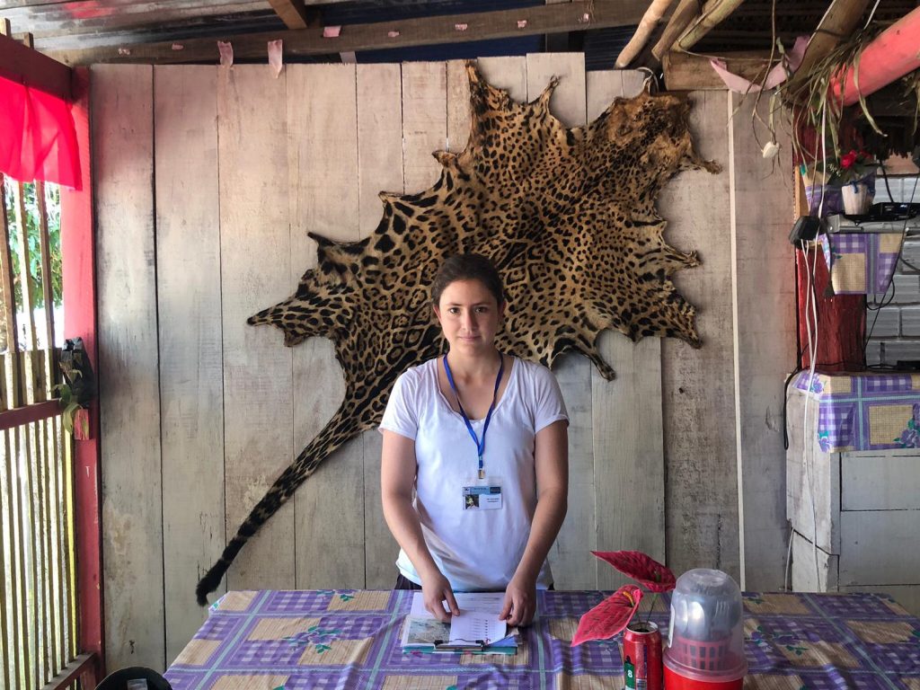 Photograph of Melissa carrying out fieldwork in Bolivia with jaguar plet behind her