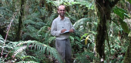 Yadvinder in the rainforest with a note book and pen