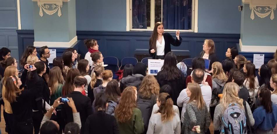 crowd watching female researcher on a spaoboc speaking