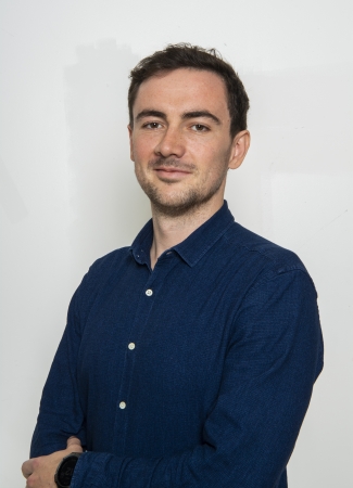 dark-haired man in a blue shirt